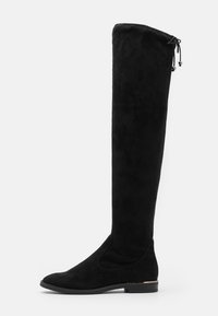 Botas negras de ante sobre la rodilla, con punta redonda y tacón bajo, que cuentan con un cierre ajustable con cordón en la parte superior.