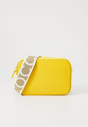 Kollane tekstuuriga nahast kott, millel on tõmblukuga sulgemine ja mustriga beež rihm. Siledad servad ja tagasihoidlik logo, mis on asetatud põhjale.