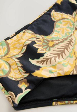 Maudymosi audinys su drąsiais geltonais ir žaliais gėlėmis juodame fone, su lygia tekstūra ir kontrastingomis siūlėmis.