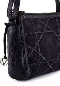 Czarna skórzana i zamszowa torba z geometrycznym przeszyciem, teksturowaną powierzchnią i złotym zamkiem błyskawicznym. Posiada okrąły metalowy akcent z logo.