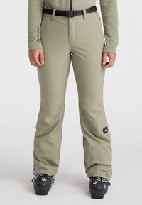 Skibroek in licht olijfgroen, gemaakt van een gladde, waterafstotende stof. Kenmerkt zich door een zwarte riem, versterkte knieën en een logopatch aan de zijkant.