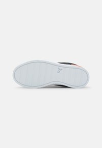 Semelle de chaussure en caoutchouc blanc avec une bande de roulement texturée. Comprend une tige noire et un accent orange près du talon. Design épuré et minimaliste.