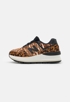 Chaussure de sport avec lacets noirs, semelle blanche et imprimé animal combinant rayures de zèbre et taches de léopard en tons marron et noir.