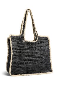 Sac fourre-tout tissé noir avec large bord crème et doubles poignées, présentant une forme rectangulaire spacieuse.