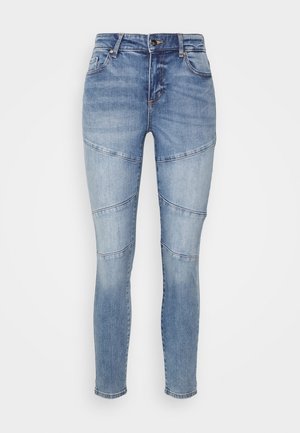 Slim fit blauwe denim jeans met kniepanelen naden, voorzakken en een knoop-ritssluiting, getoond op een effen achtergrond.