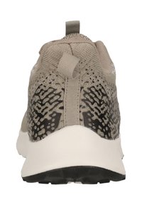 Beige sportskor med en texturerad överdel, som har ett mönstrat mönster på sidorna och en svart sula. Inkluderar en dragflik i tyg.