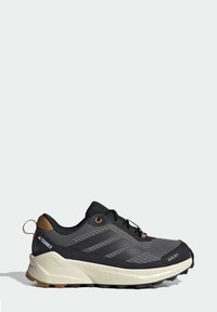Chaussures de randonnée noires et grises avec un dessus en maille texturée, une semelle extérieure en caoutchouc et une semelle intermédiaire de couleur claire. Elles disposent d'un système de laçage et d'accents de logo.