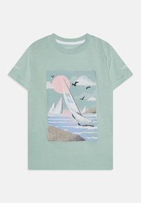 Hellgrünes Baumwoll-T-Shirt mit einem Grafikdesign von Segelbooten, Wellen und einer Sonne. Kurze Ärmel mit Druckdetails auf dem linken Ärmel.