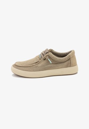 Zapatilla casual beige con parte superior de lona, puntera redonda, cuello acolchado, suela beige y cordones elásticos con detalles en azul claro en el lateral y en la lengüeta.