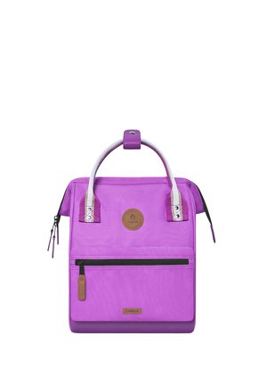 Purple square-shaped backpack with white handles, front zip pocket, and brown leather logo patches, shown on a white background.
