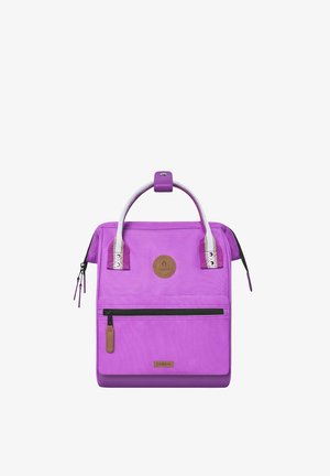 Purple square-shaped backpack with white handles, front zip pocket, and brown leather logo patches, shown on a white background.
