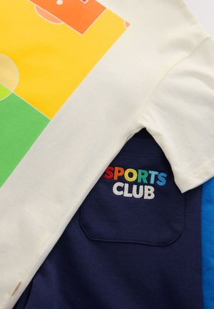 Katoenen T-shirt met een kleurrijke geometrische print in geel, oranje, groen en lichtblauw, met "SPORTS CLUB" geborduurd in regenboogkleuren.