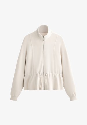 Felpa beige chiaro con zip, colletto alto, vita elasticizzata arricciata e maniche lunghe. Materiale morbido con dettagli delle cuciture visibili.