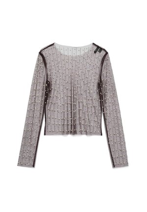 Genomskinlig, långärmad topp i ljuslila med ett prickigt mönster av små, runda dekorationer. Avslutad med mörklila trim längs kanterna.