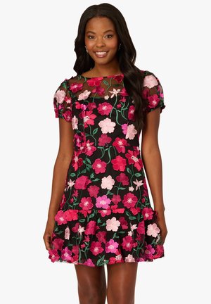 Vestito nero con maniche corte a sbuffo, caratterizzato da un ricamo floreale colorato in rosa e verde. Orlo arricciato che aggiunge volume al design.