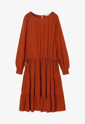 Rūsganas krāsas kleita ar garām piedurknēm, smalkiem pleciem, aukliņas viduklī un slāņainu volānu apakšmalu. Izgatavota no viegla auduma.