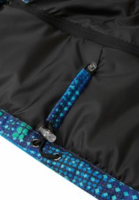 Schwarzer Stoff mit blauem und grünem gemusterten Besatz. Verfügt über eine kleine Reißverschlusstasche und einen verstellbaren Kordelzug mit Plastikverschluss. Glatte Textur.