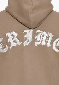 Hoodie marron avec un grand texte brodé blanc portant le mot "CRIME" dans une police décorative et stylisée dans le dos. Texture douce.