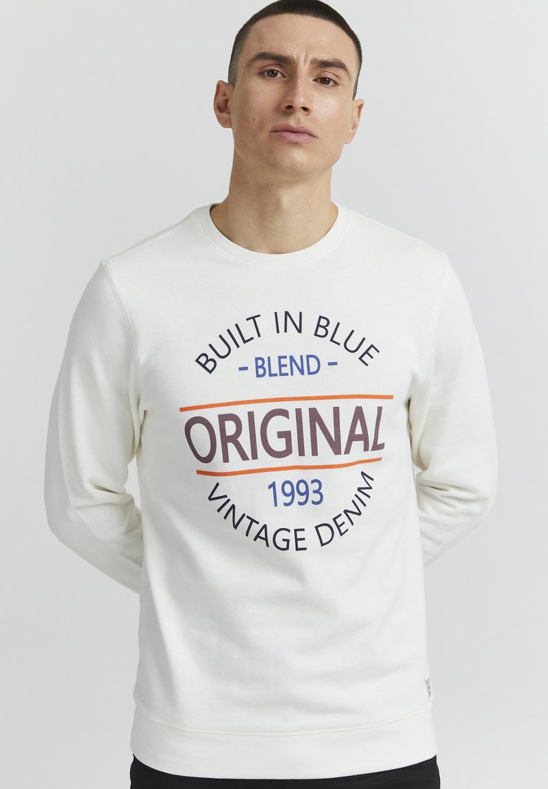 Felpa bianca con maniche lunghe e colletto rotondo. Nella parte anteriore presenta le scritte "BUILT IN BLUE", "ORIGINAL 1993" e "VINTAGE DENIM" stampate in multicolor.
