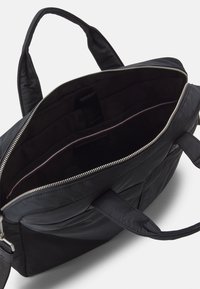 Czarna torba na laptopa z otwartym zamkiem, ukazująca wyściełaną komorę wewnętrzną i podwójne uchwyty na białym tle.
