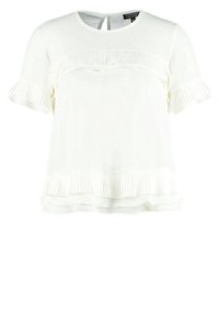 Bílý top s krátkým rukávem, který má volánkovou část a plisované detaily. Hladká látka s volným střihem a kulatým výstřihem.