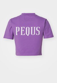 Violetinis trumpas marškinėlis, pagamintas iš minkštos medžiagos, turintis trumpas rankoves ir žodį "PEQUS" atspausdintą baltai ant nugaros.