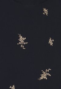 Marine textiel met gouden bloemen borduurwerk. Bevat kleine, verspreide bloemmotieven op een gestructureerde achtergrond. Ronde halslijn.