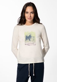 Crèmekleurig shirt met lange mouwen, voorzien van een grafische print van een handtas met een strik en de tekst "SHORT STORIES" in een gelaagde pastelkleurencombinatie.