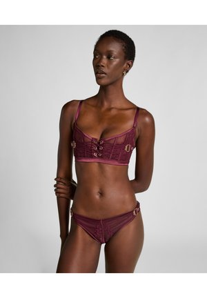 Burgunderfarbenes Dessous-Set mit einem Bralette mit Schnürung an der Vorderseite und goldfarbenen Akzenten, kombiniert mit passenden Bikinis und weichem, durchsichtigen Stoff.