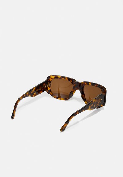 Tortoiseshell sunglasses with a square frame, brown lenses, and slender arms featuring a subtle glossy finish and geometric patterns.