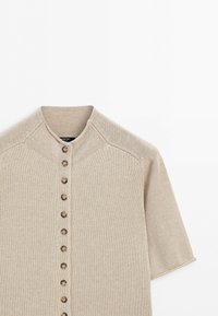 Beige short-sleeve knit cardigan with a round neckline and a vertical row of brown buttons down the front.
