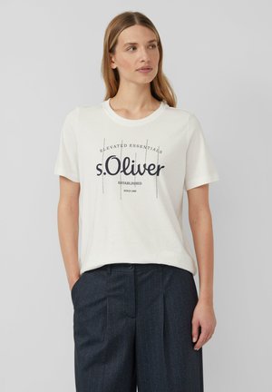 T-shirt en coton blanc avec un col rond et des manches courtes, imprimé avec "s.Oliver" et un texte supplémentaire en bleu marine. Porté avec un pantalon à rayures sombres.