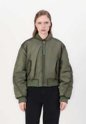Giacca bomber verde oliva realizzata in un materiale liscio e lucido, con chiusura a zip, polsini a coste e due tasche frontali.