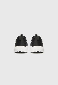Black athletic sneakers with a textured upper, white cushioned sole, and back pull-tabs. Features contrasting side accents.
