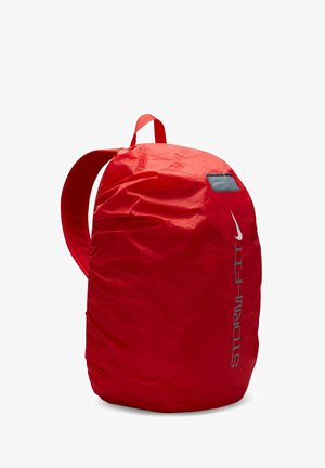 Sac à dos rouge en nylon de forme arrondie, avec un compartiment de stockage proéminent et des bretelles réglables. Il possède une petite fenêtre pour l'identification.