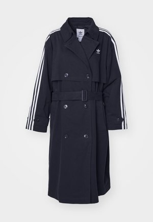 Manteau noir en trench avec fermeture croisée, taille ceinturée et motif à trois rayures blanches sur les manches. Il présente un tissu lisse et un col cranté.