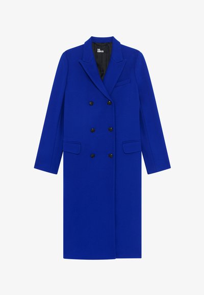 Doppelreiher Mantel aus blauer Wolle mit Schalkragen, zwei vorderen Taschen und schwarzen Knöpfen. Glatte Textur mit taillierter Passform.