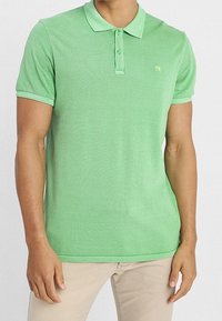 Zielona koszulka polo wykonana z fakturowanej tkaniny, z dwu guziczkowym zapięciem, krótkimi rękawami i małym akcentem logo na klatce piersiowej.