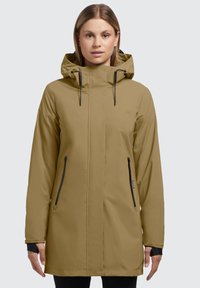Parka imperméable couleur khaki avec capuche, deux poches avant zippées, cordons de serrage ajustables et accessoires noirs.