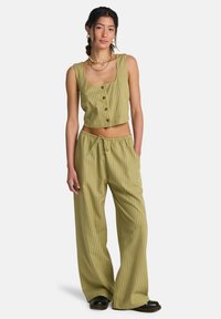 Ensemble deux pièces à rayures vertes comprenant un débardeur court à boutons et un pantalon large avec une taille à cordon ajustable.