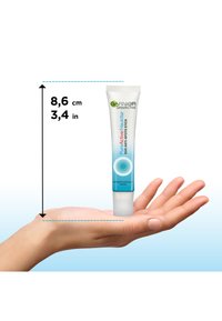 White, squeeze tube with blue accents, measures 8.6 cm tall, labeled "Pure Active," held in a hand against a gradient background.
