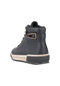 Basket haute en cuir noir avec une finition texturée, des accents en matériel doré et une semelle en caoutchouc crème. Présente une fermeture éclair et un détail de logo.