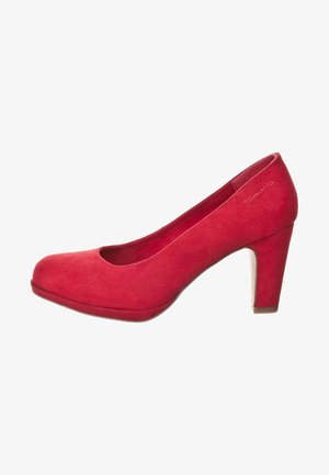 Zapato de tacón alto de ante rojo con punta redondeada, textura suave y un tacón cuadrado resistente. Diseño simple, sin patrones o adornos visibles.