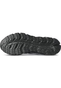 Sole di scarpa sportiva nera con un battistrada multi-direzionale, scanalature e un design maculato. Realizzata in gomma per garantire trazione e durata.