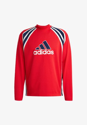 Sarkans garās piedurknes sporta krekls ar acs tekstūru, tumši ziliem un baltajiem svītrainajiem akcentiem, kā arī centrālo melno Adidas logo.