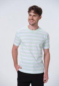 Bomulds T-shirt med horisontale lysegrønne og hvide striber, rund hals, korte ærmer og en afslappet pasform.