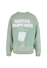 Grønn hettegenser med et hvitt motiv av en kopp med et sugerør og teksten "MATCHA MORNINGS" på baksiden. Myk bomullsmateriale, avslappet passform.