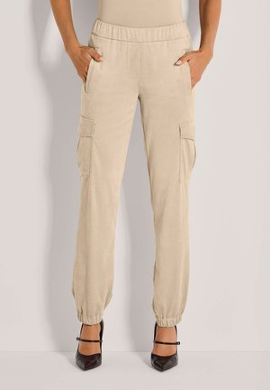 Beige cargobroek met een elastische tailleband, twee zijzakken en twee zijcargozakken. Tapered boorden bij de enkels. Gladde textuur.