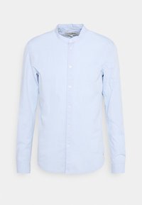 Ljust blå långärmad skjorta med bandkrage, knappstängning och en mjuk bomullstextur; har vita knappar och en rundad fåll.