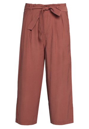 Pantalons larges de couleur rouille en tissu léger avec une taille ceinturée et des plis à l'avant, présentant une texture lisse et sans motifs visibles.